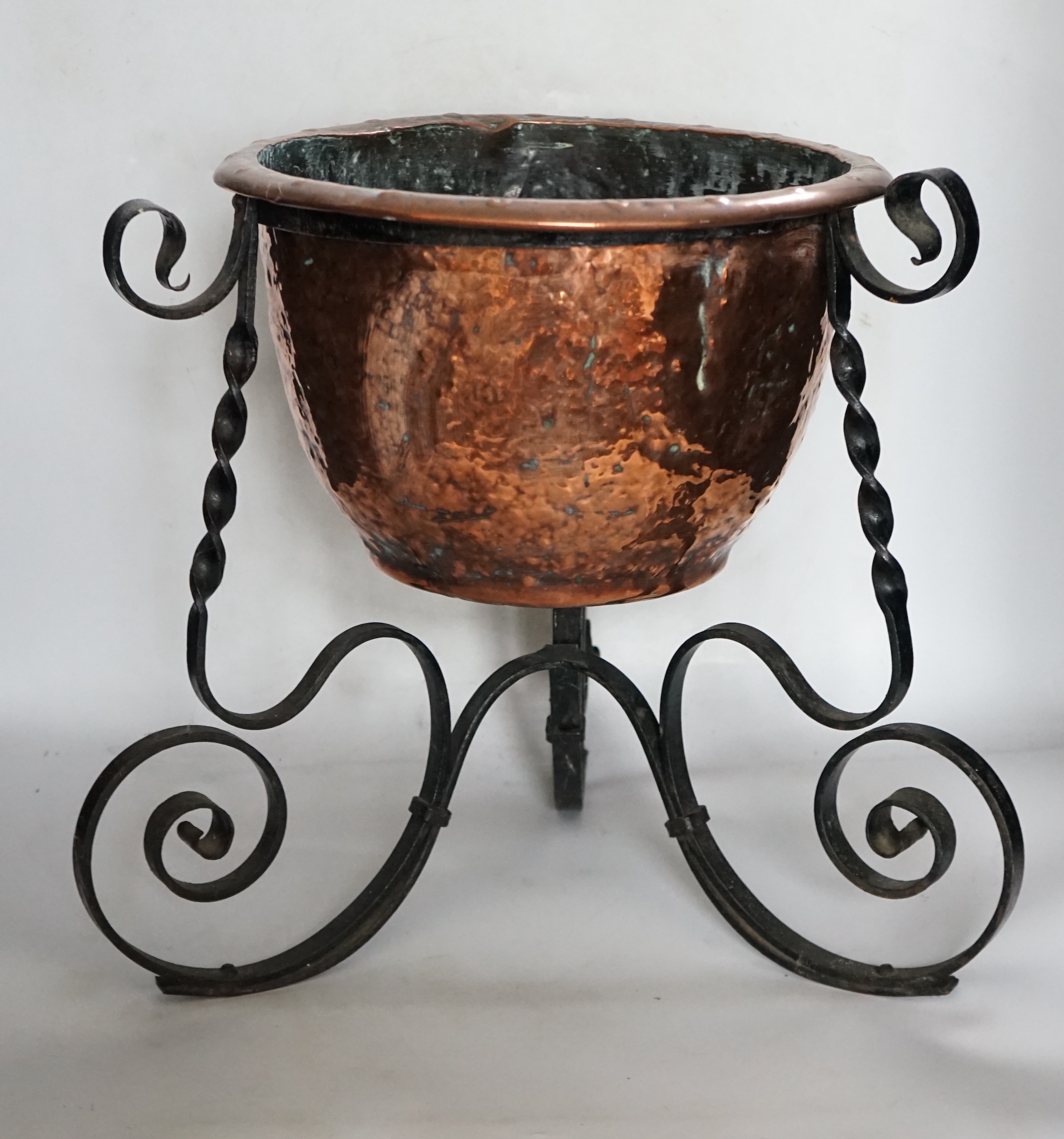 An Edwardian wrought iron and copper jardiniere